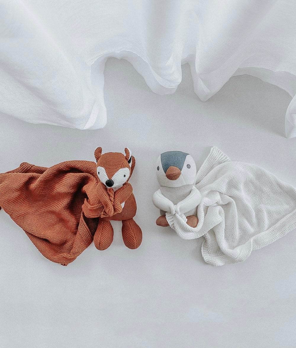 Two soft toys, one resembling a fox and the other a puffin, on a white background.