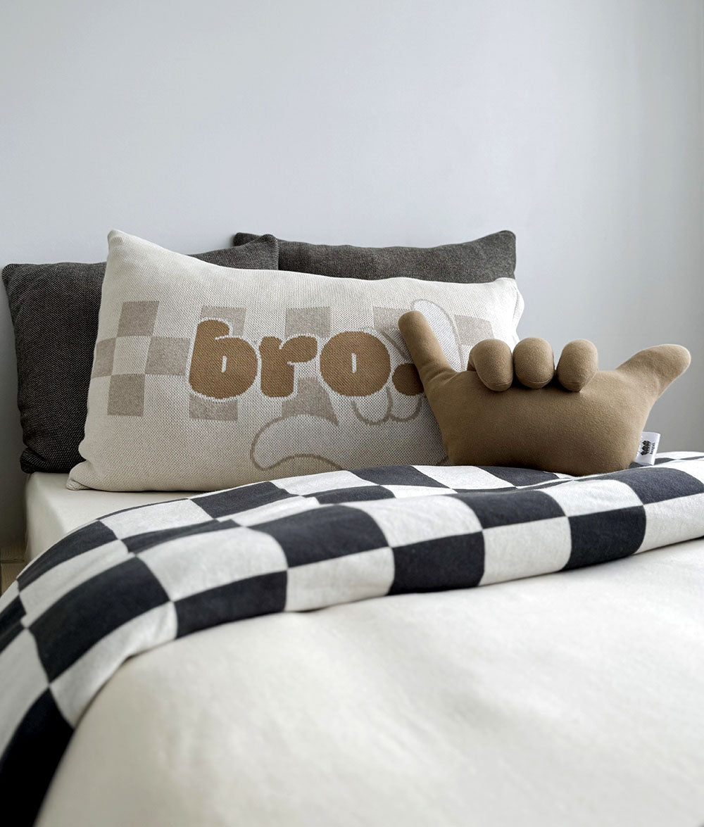 Decorative pillows on a bed with a checkered blanket