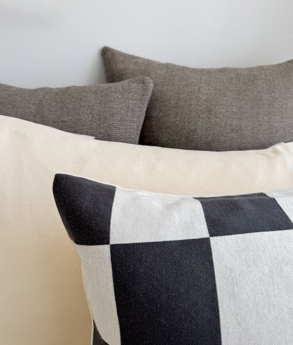 Three pillows with different patterns on a neutral background