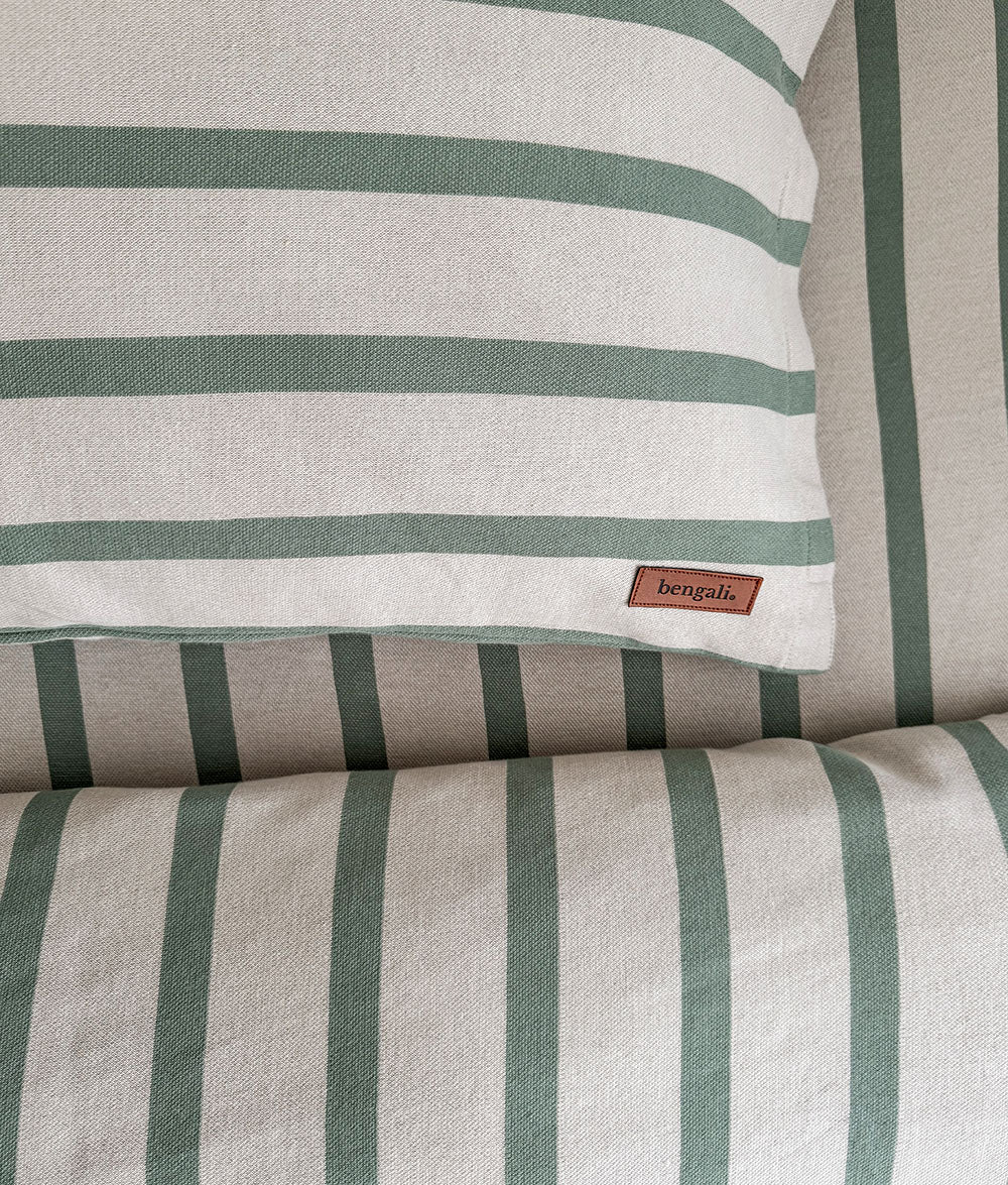 Striped pillow with a brand label on a matching fabric background