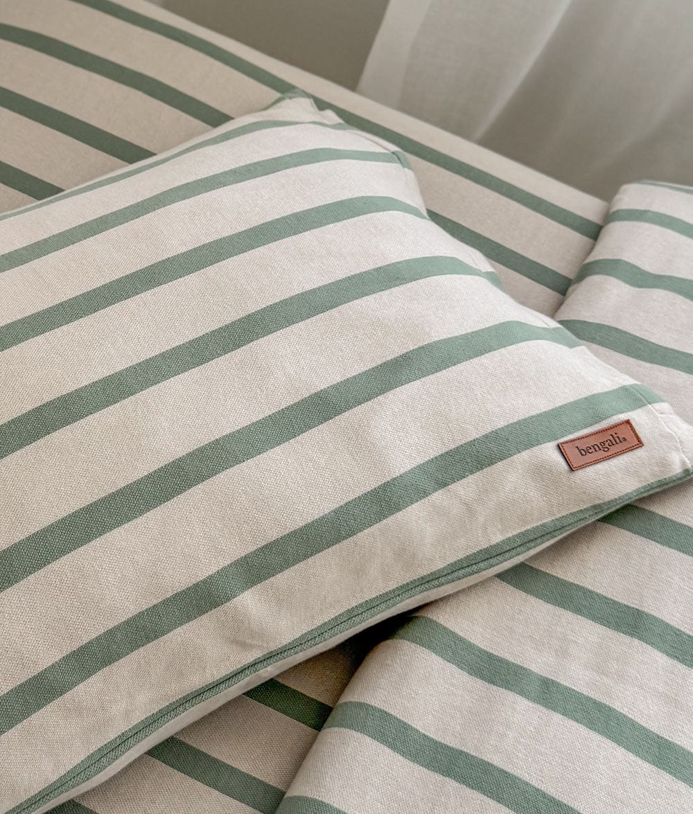 Striped pillow and blanket with a brand label on a bed