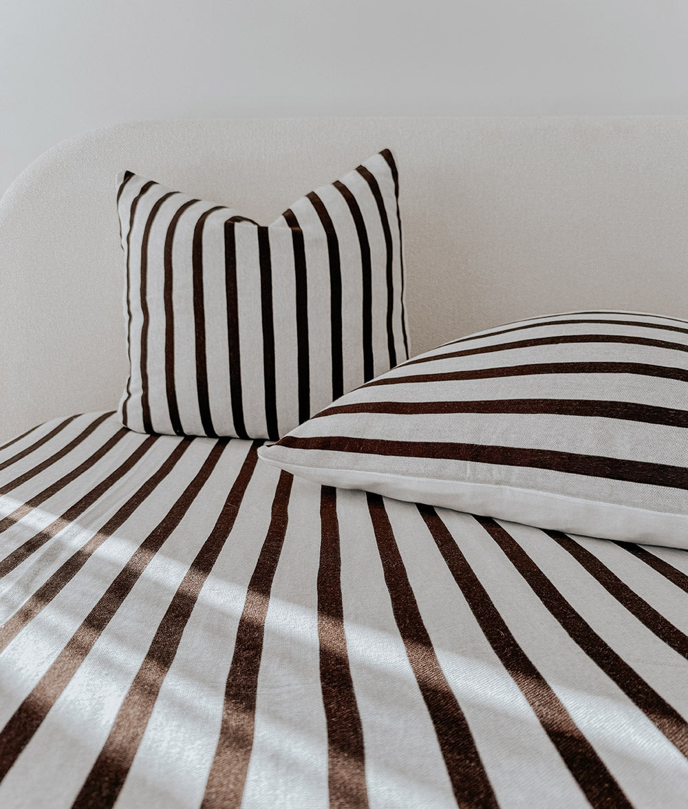 Sundown Stripe jersey cotton fitted sheet styled on a child's bed.