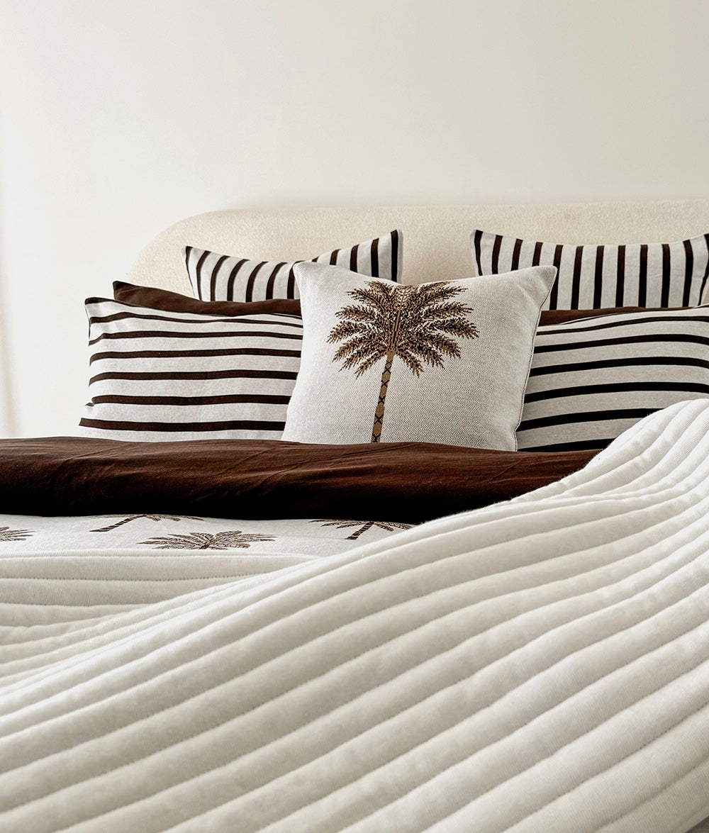 Palm Motif cushion cover styled with Sundown Stripe bedding.