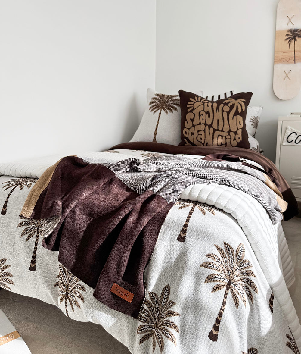 "Stay Wild Ocean Child" cushion cover styled with Khaki Sundown bedding.