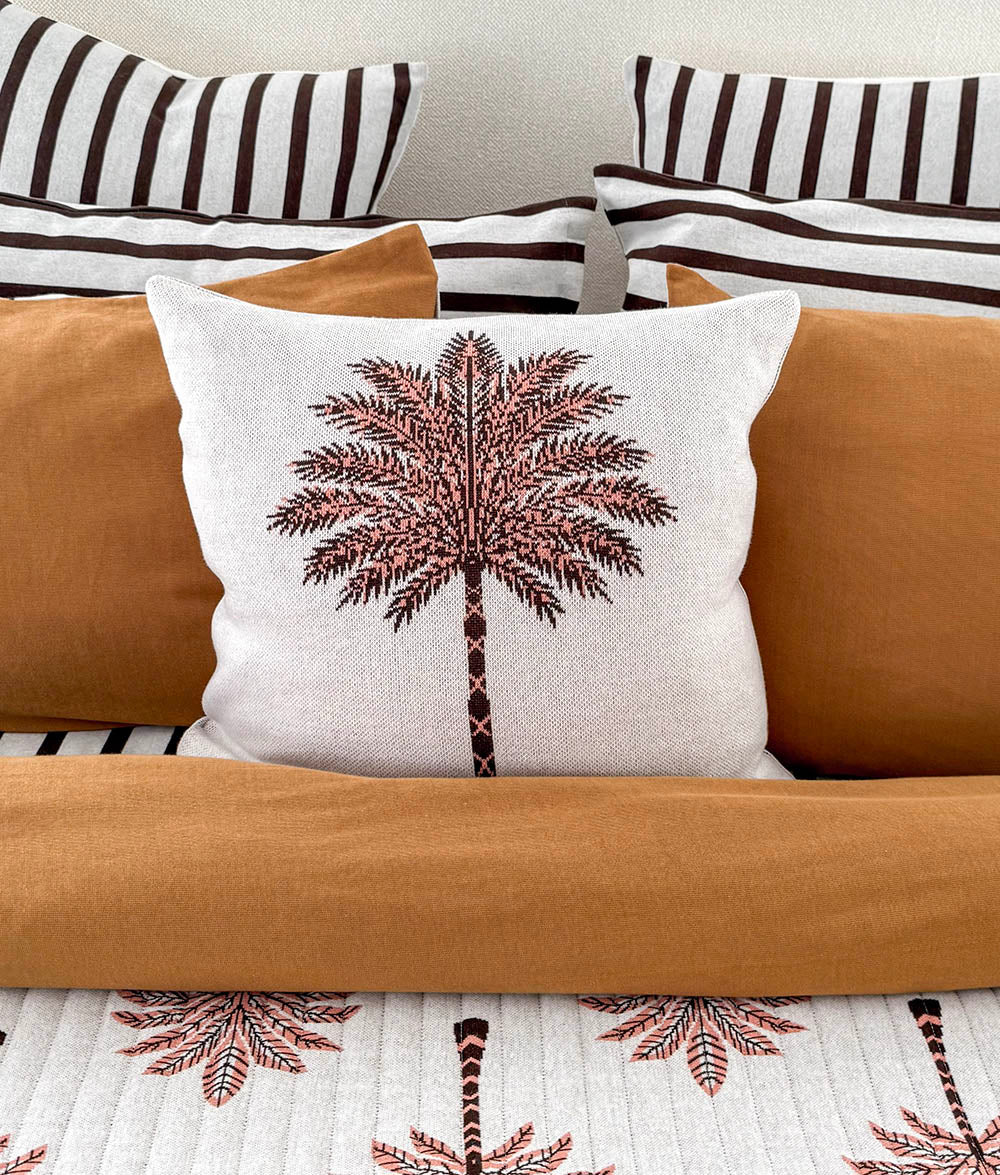 Peach Sundown Palm Motif cushion cover on an ivory background.