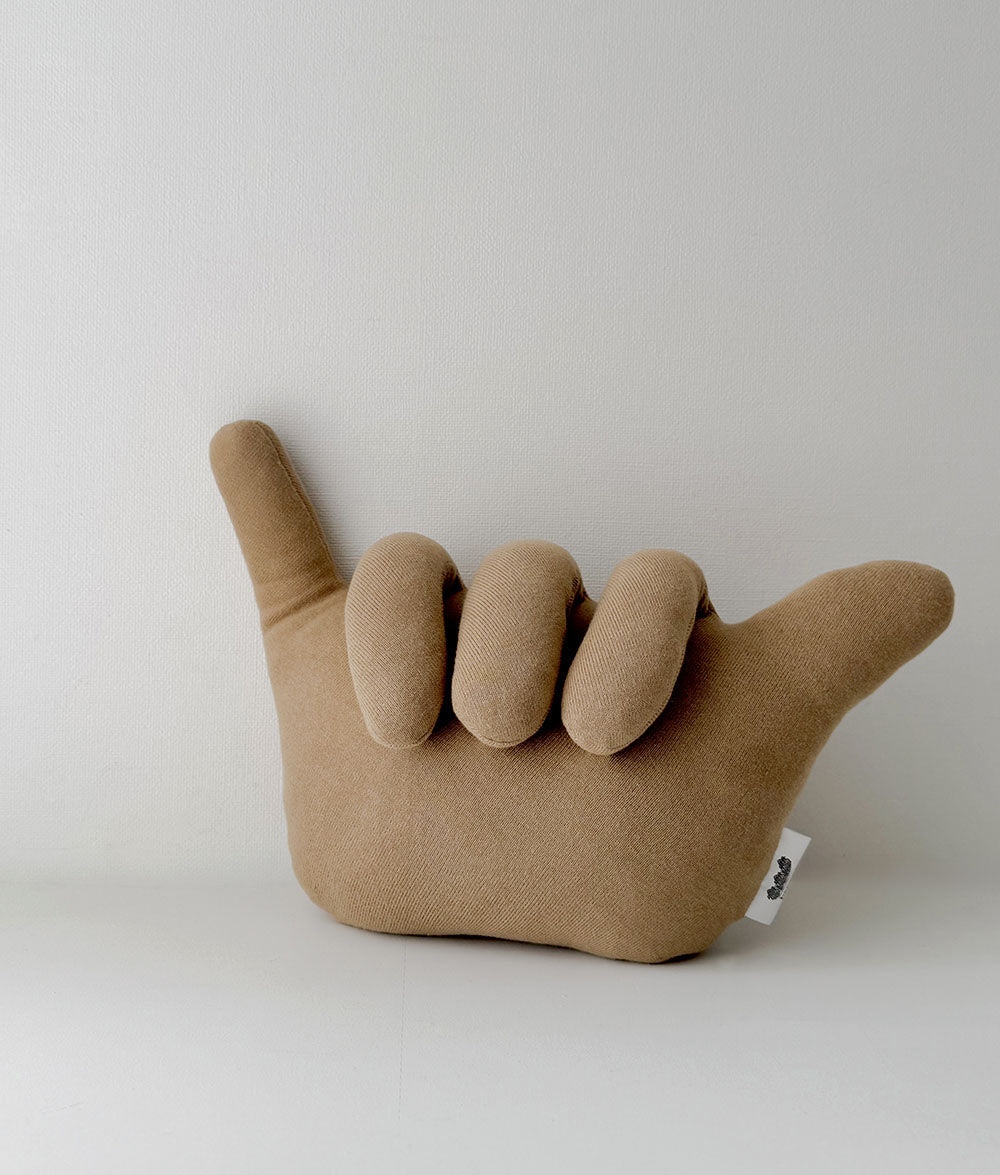 Brown plush hand pillow with a unique shape on a white background
