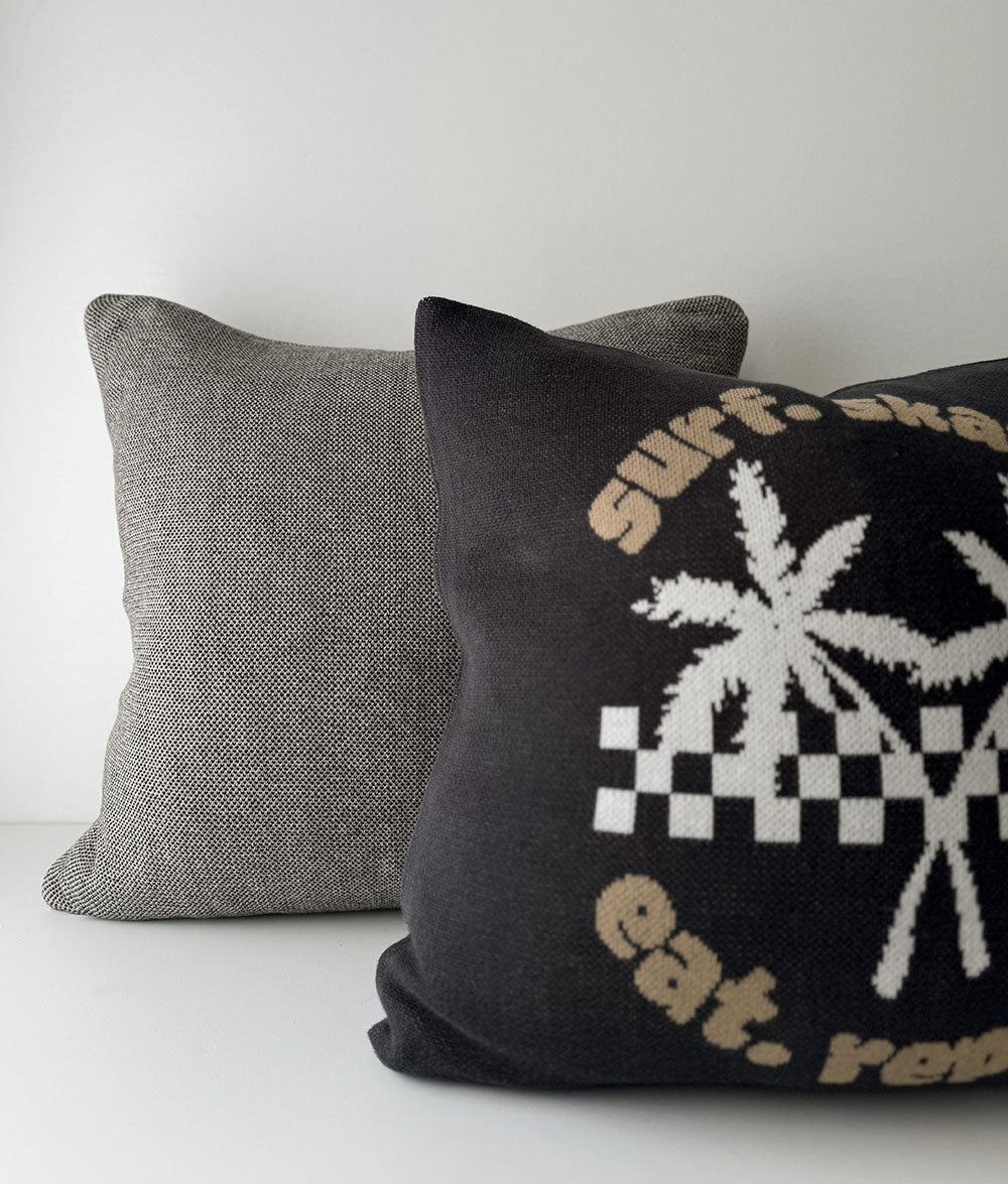 Gray pillow and black pillow with graphic design on a white background