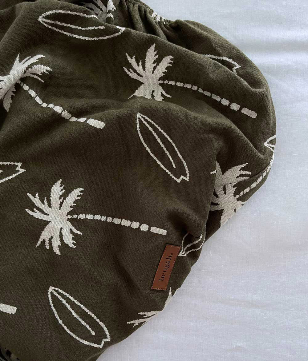Olive Surfing Palm jersey cotton fitted sheet folded with Bengali leather label.