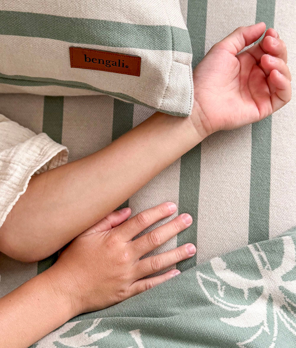 Close-up of a striped fabric with a 'bengali' label, showing a hand touching the material.