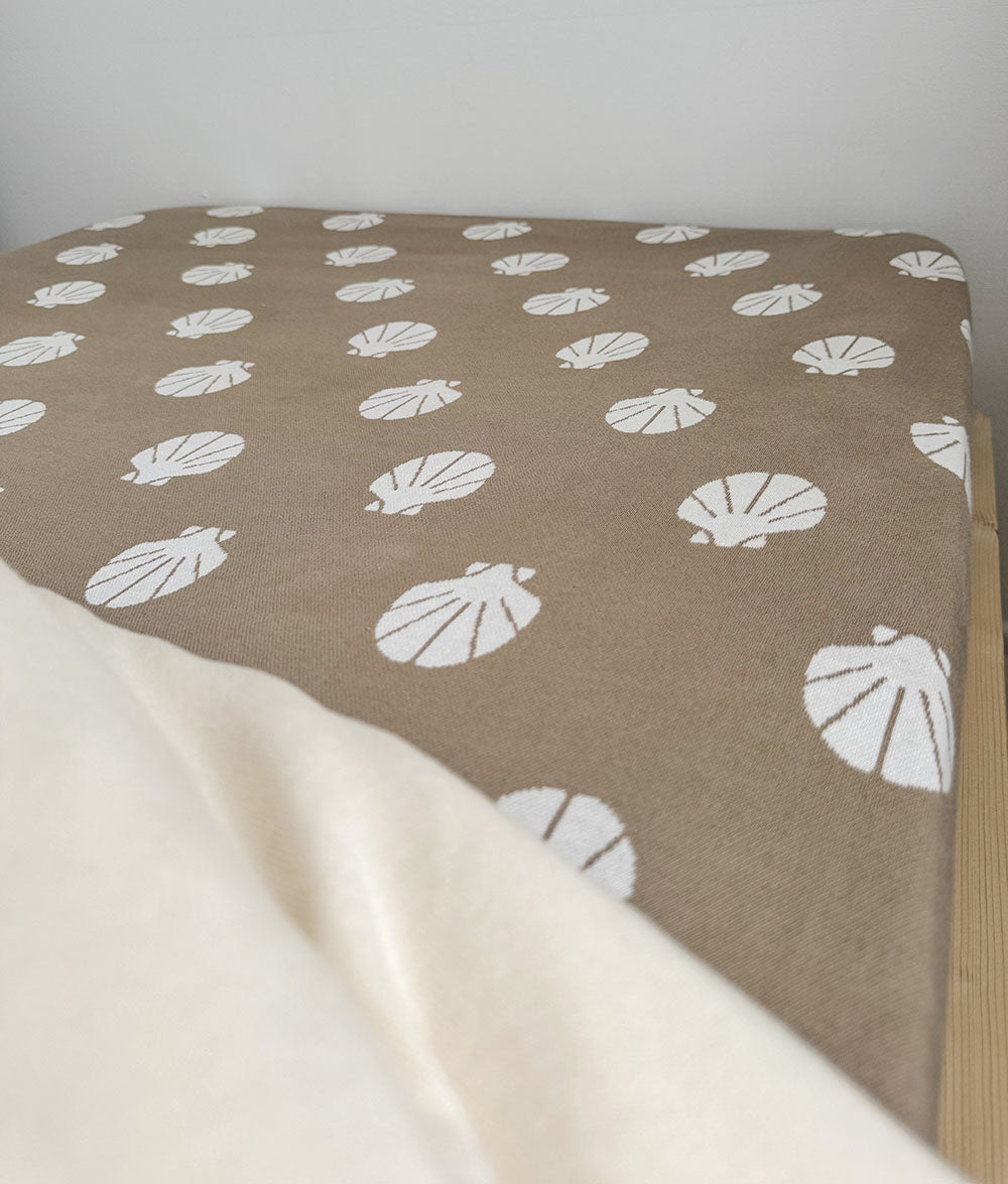 Brown fabric with white shell pattern on a white background