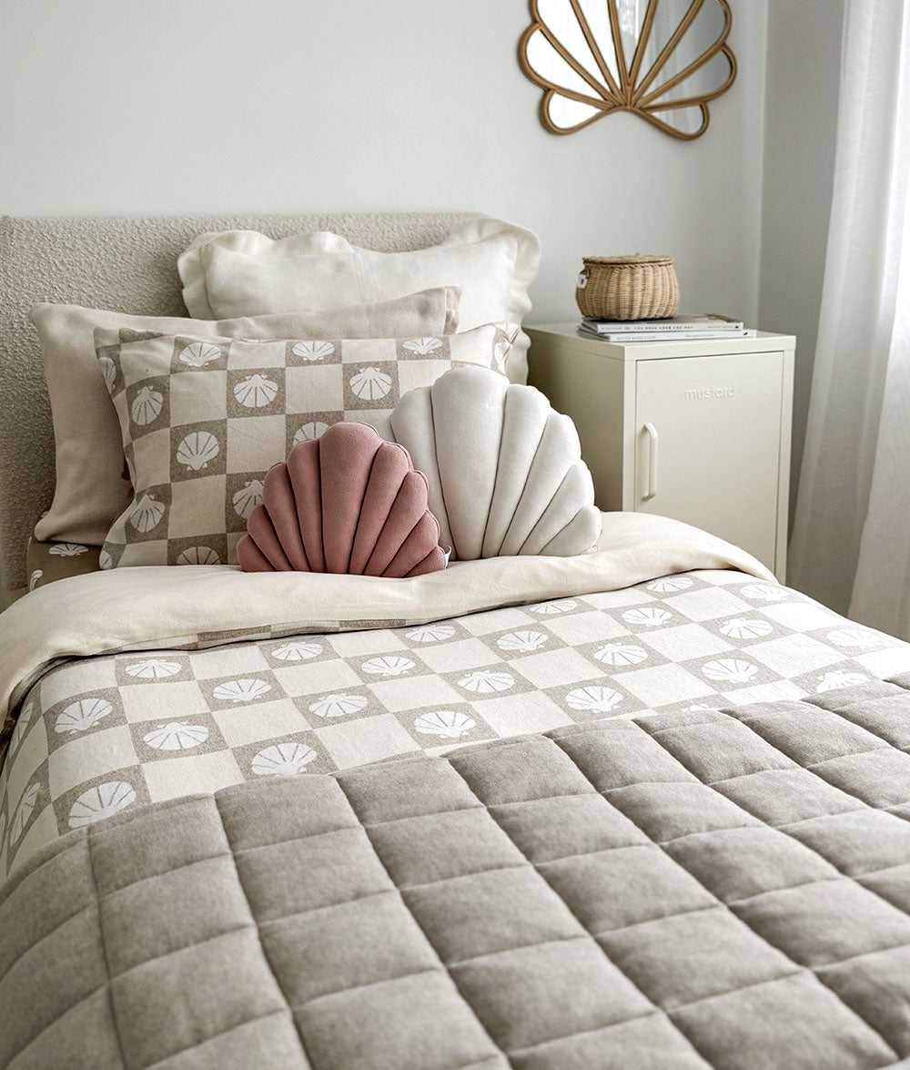 Bed with patterned comforter and pillows in a bedroom setting