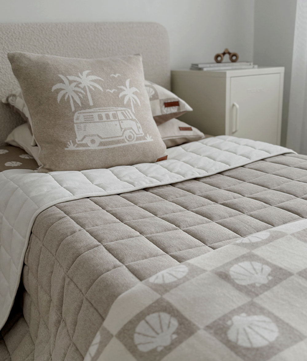 Bed with patterned comforter and pillows in a bedroom setting