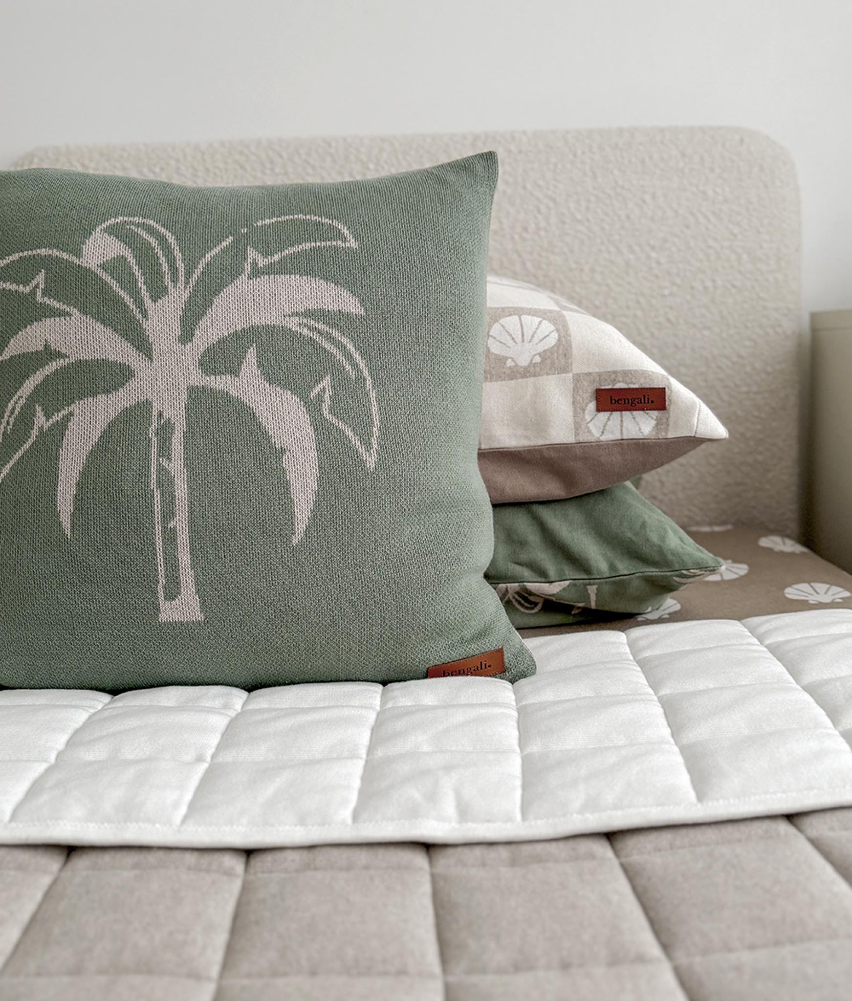 Decorative pillows with palm tree design on a bed