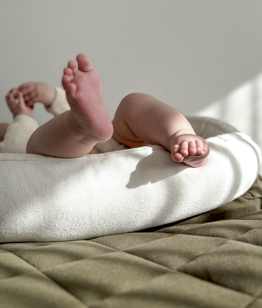 Baby resting in the Ivory & Olive Baby Lounger.