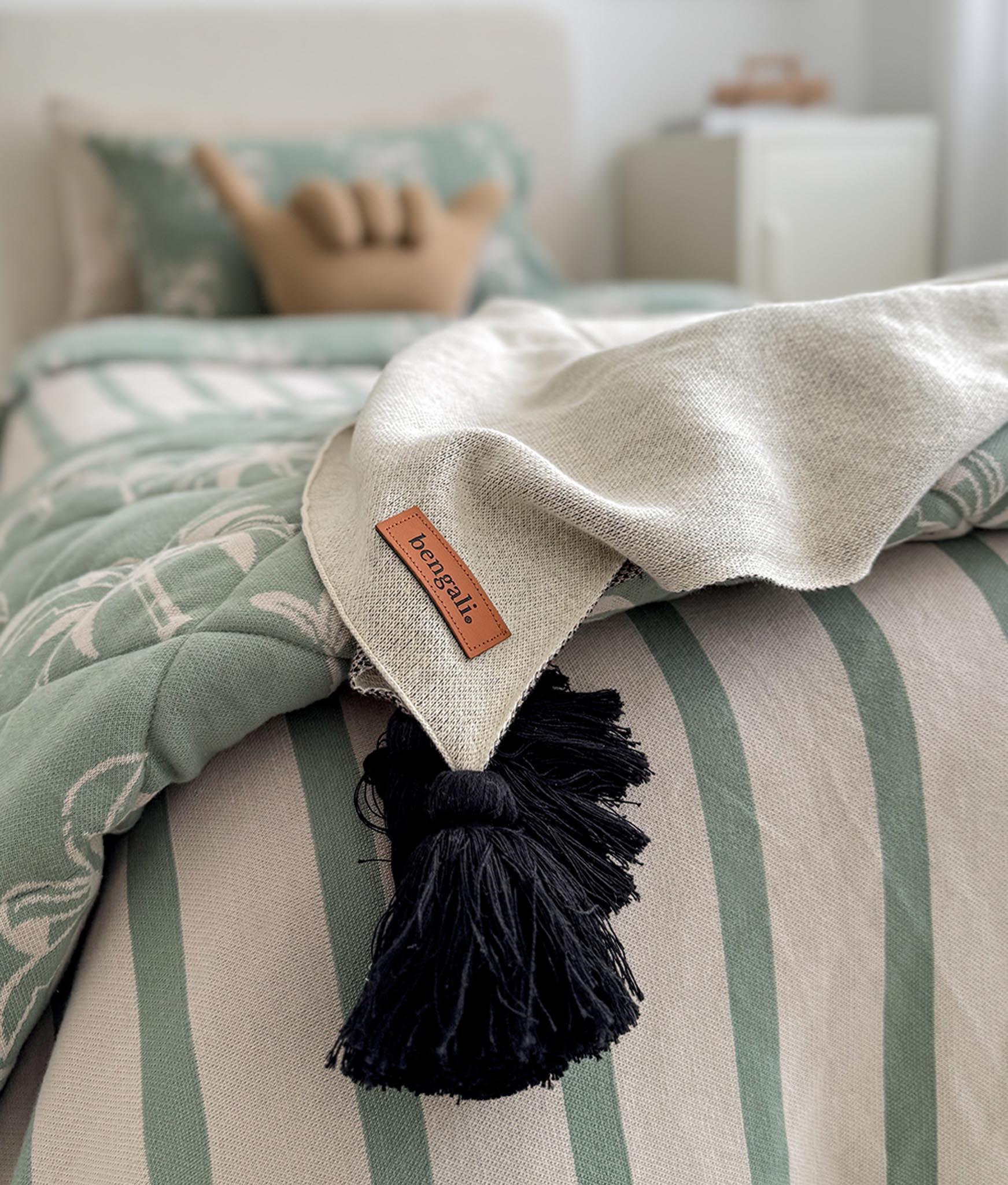 Textile with tassel and brand label on a striped fabric background