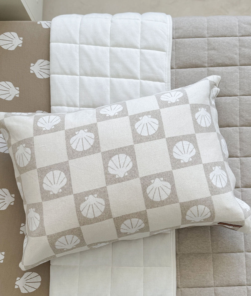 Decorative pillow with shell pattern on a checkered fabric background