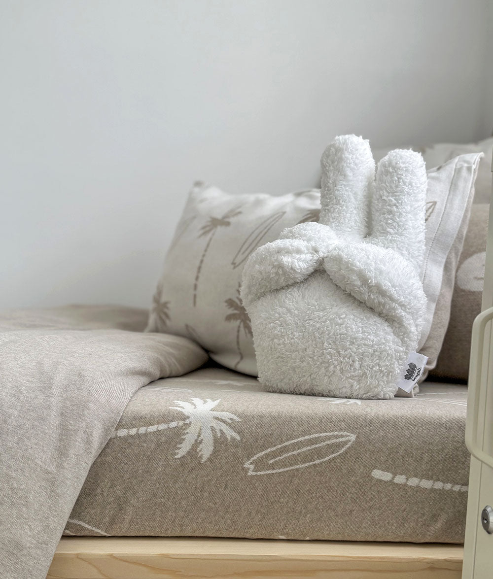 Cozy bedroom with a plush peace toy on a bed with patterned bedding.