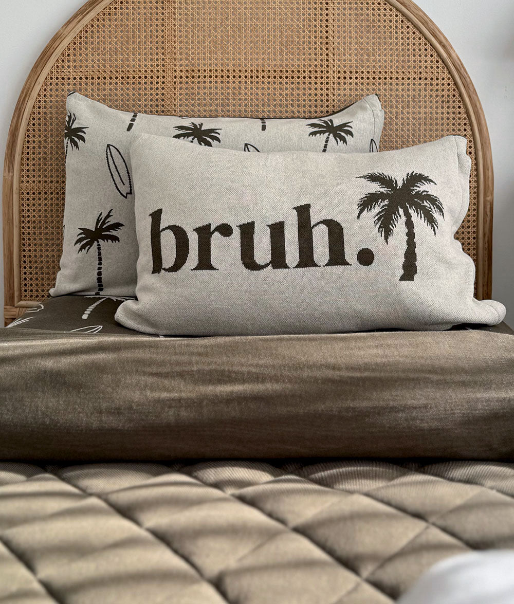 Olive & Natural Marle "bruh." reversible pillowcase styled on a bed.