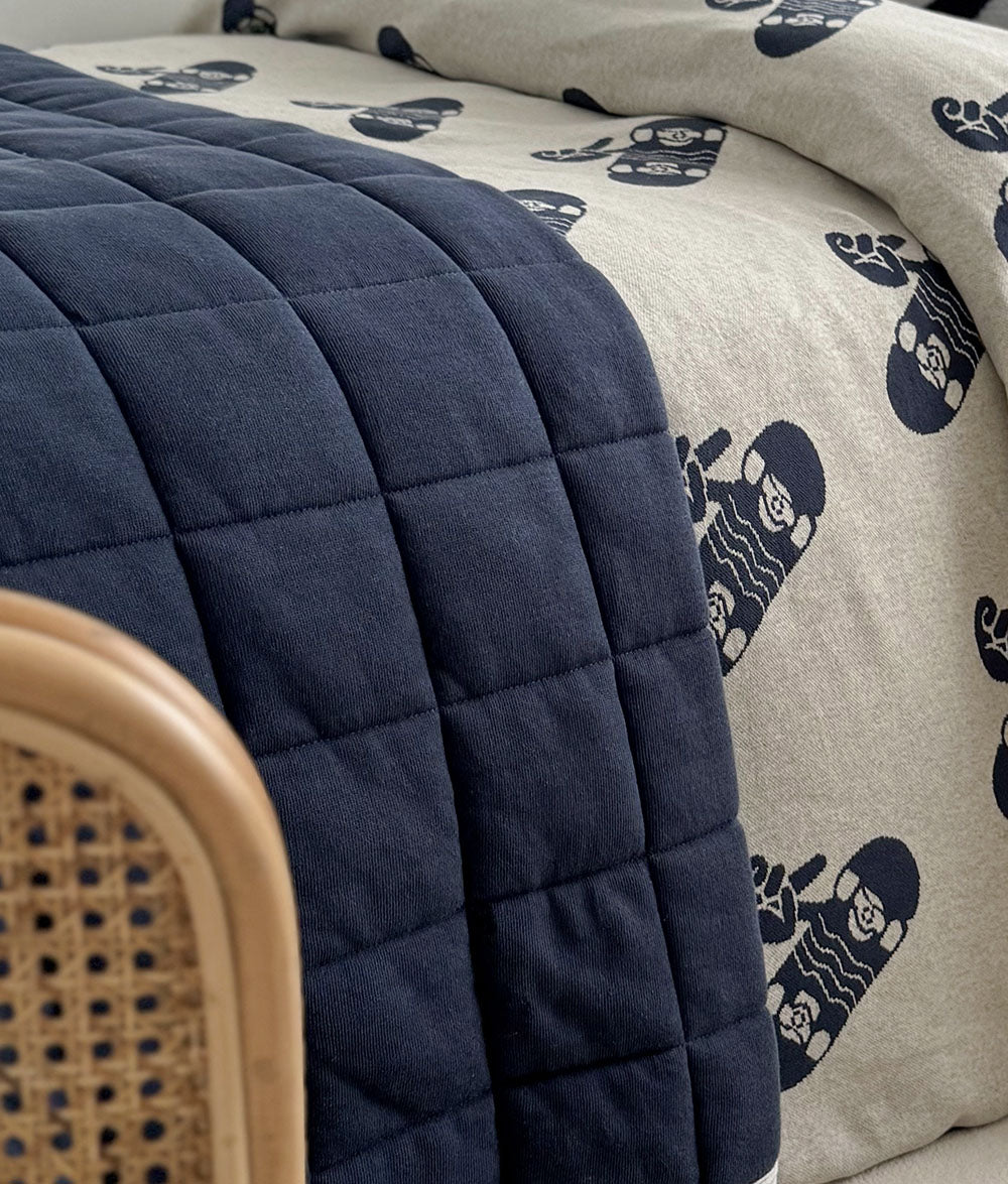 Close-up of the Tidal Blue quilt on Skater Life bedding.