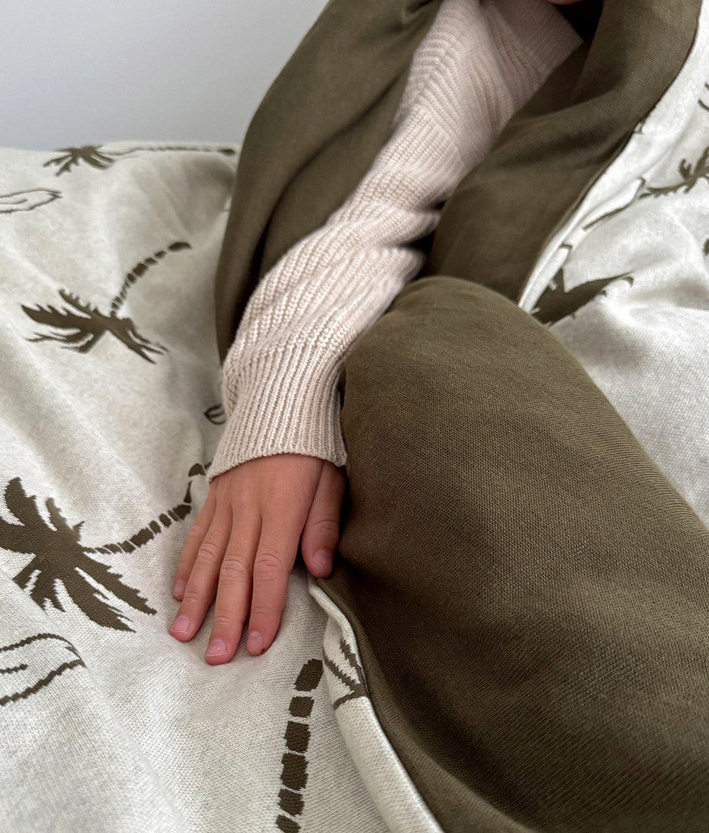 Close-up of Olive Surfing Palm duvet cover and jersey cotton fabric.
