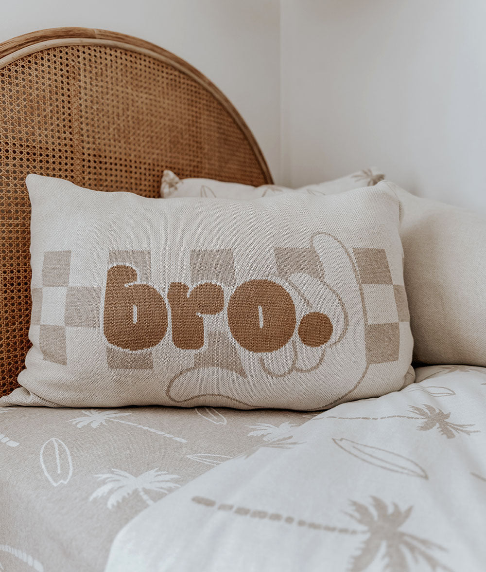 Decorative pillow with 'bro.' text on a couch
