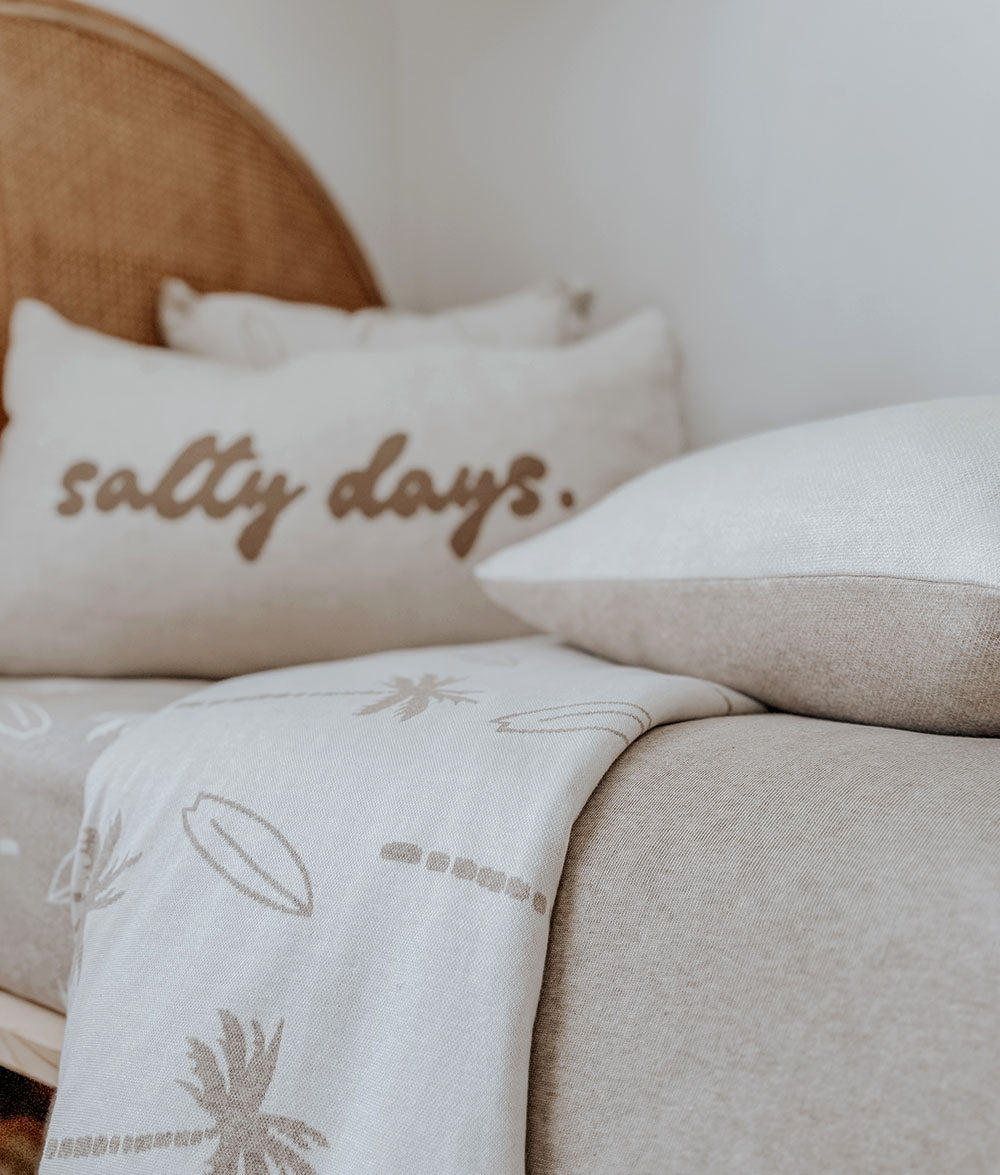 Decorative pillows with 'salty days' text on a couch