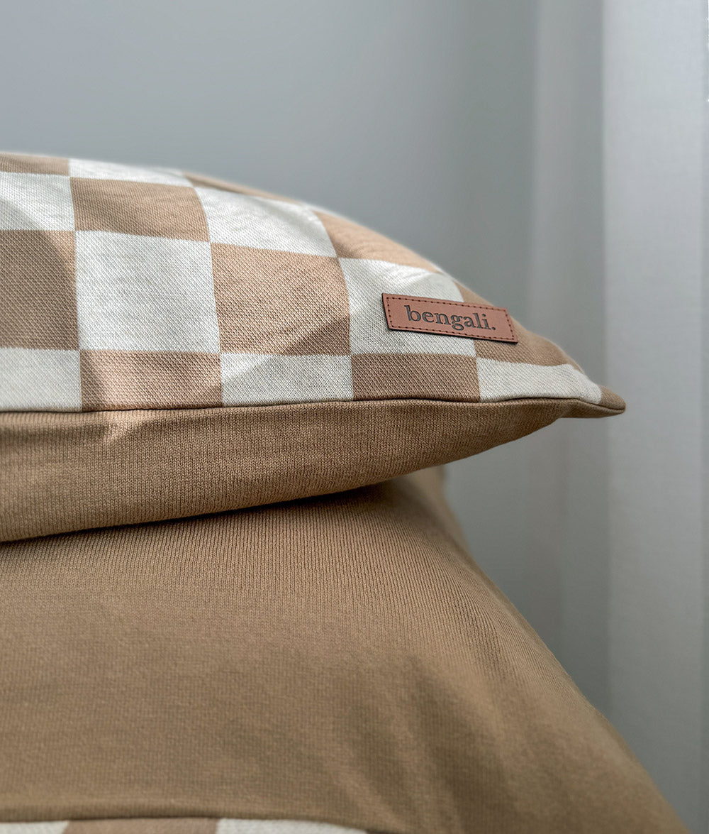 Close-up of the Khaki Gingham Euro pillowcase with plain khaki bedding.