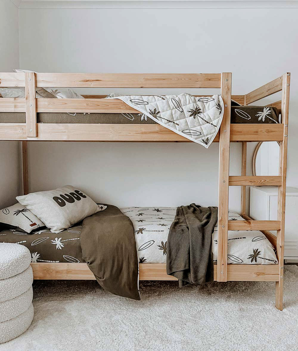 Olive Surfing Palm bedding styled on wooden bunk beds.