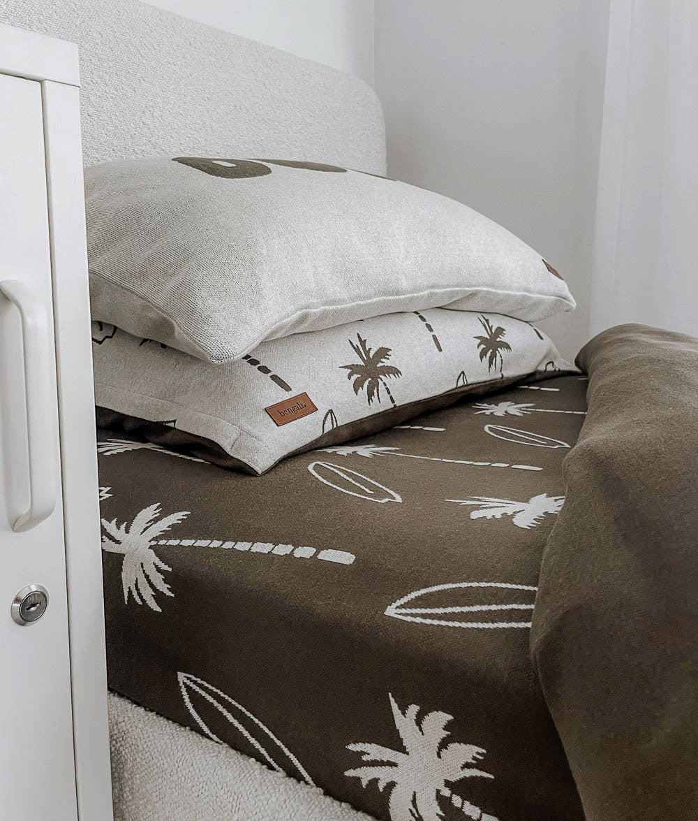 Olive Surfing Palm jersey cotton fitted sheet styled on a single bed.