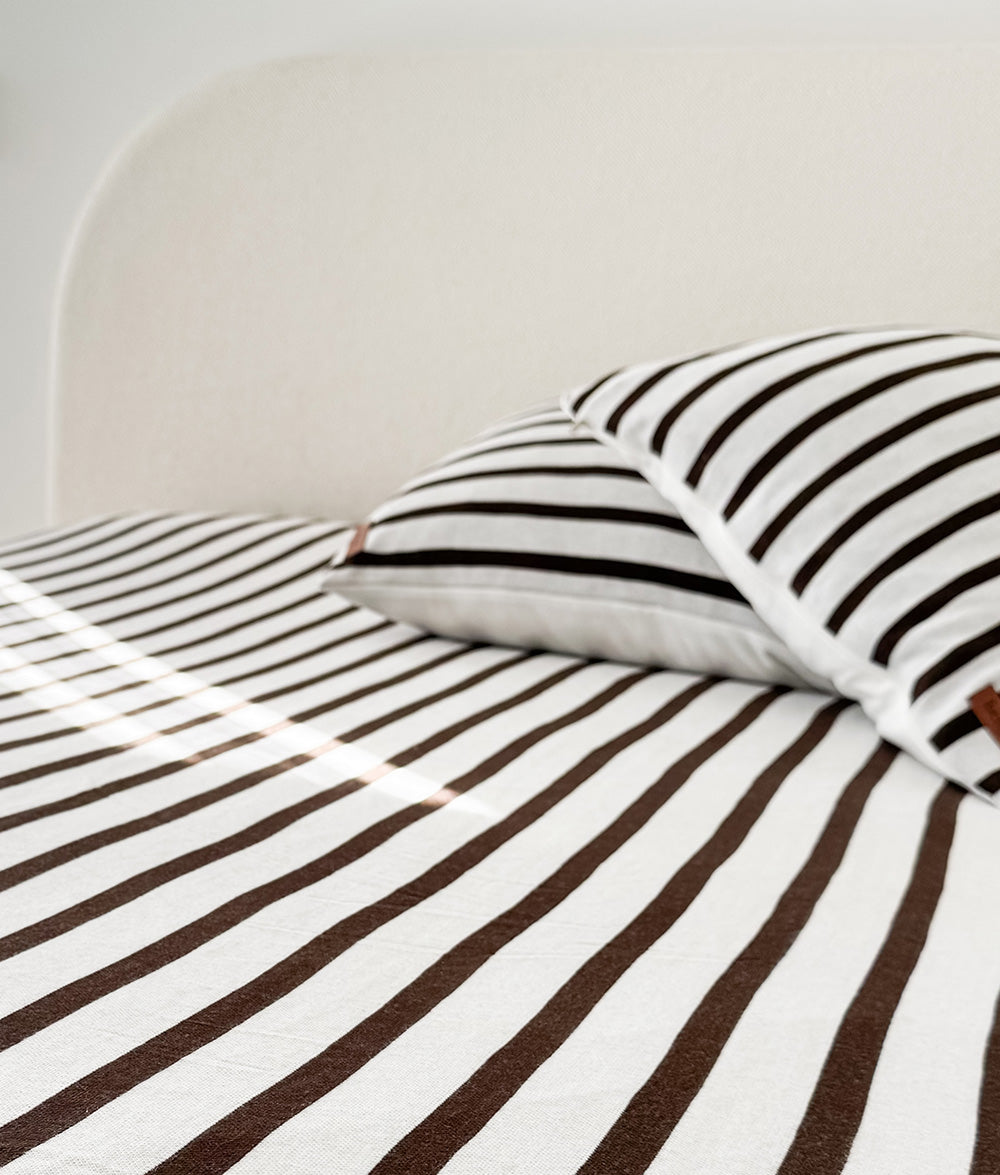 Close-up of the Sundown Stripe jersey cotton fitted sheet and pillowcase.