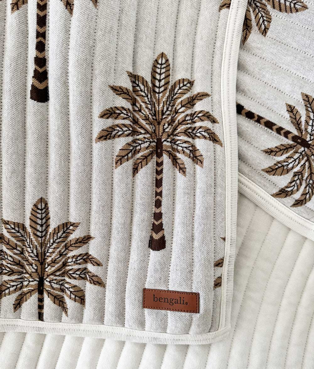Close-up of the Khaki Sundown reversible quilt showing palm tree print.
