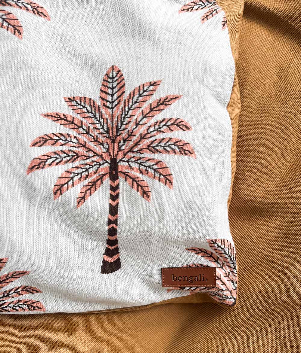 Close-up of the Peach Sundown jersey cotton duvet cover with peach and chocolate palm tree print.