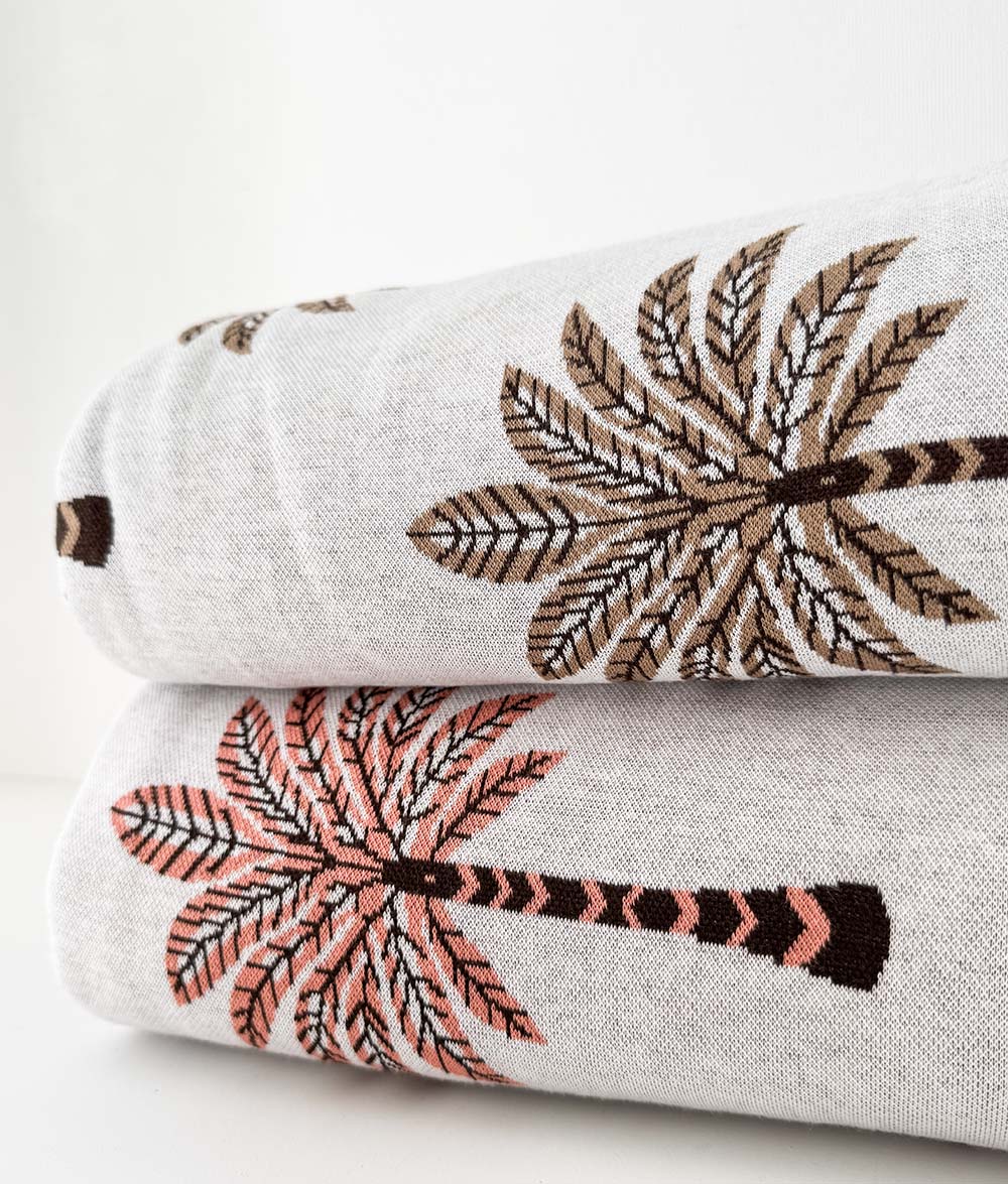 Folded Peach Sundown and Khaki Sundown jersey cotton duvet cover showing palm tree designs.