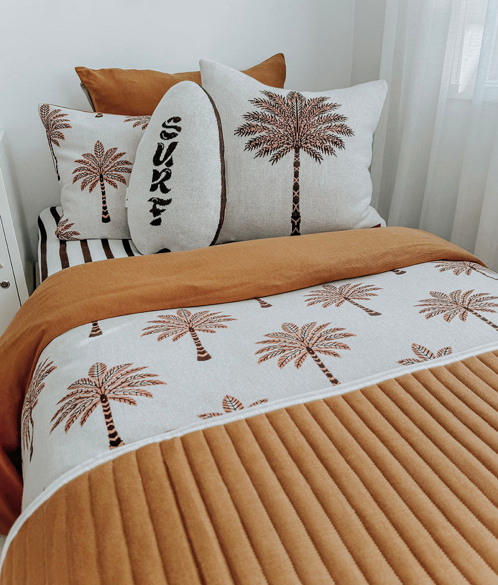 Peach Sundown reversible quilt with plain tobacco reverse and matching bedding.