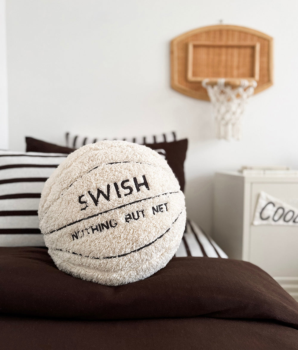 Sherpa basketball play cushion styled on a child's bed.