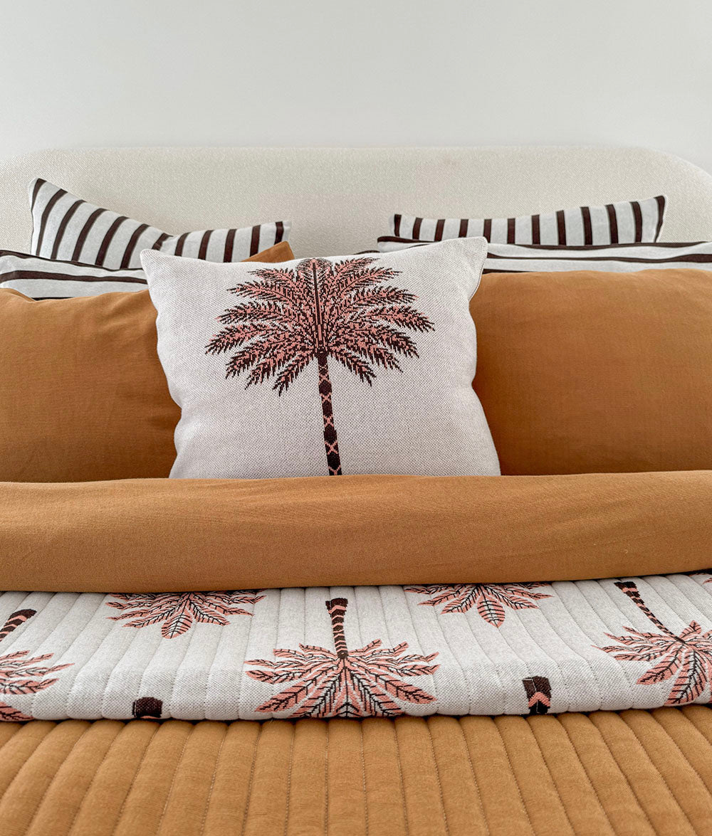Peach Sundown reversible quilt styled with matching Palm Motif cushion.