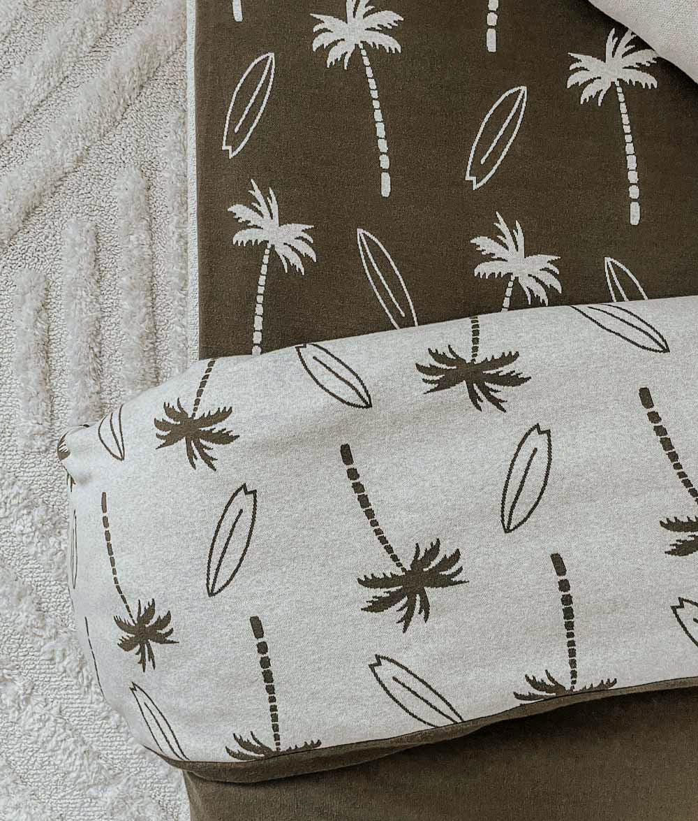 Close-up of Olive Surfing Palm pillowcase and duvet cover.