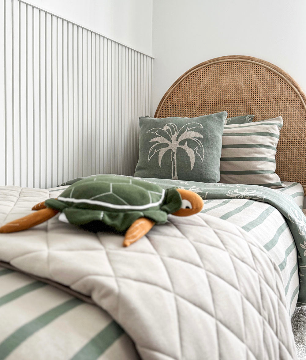 Bed with turtle plush toy and decorative pillows in a bedroom setting