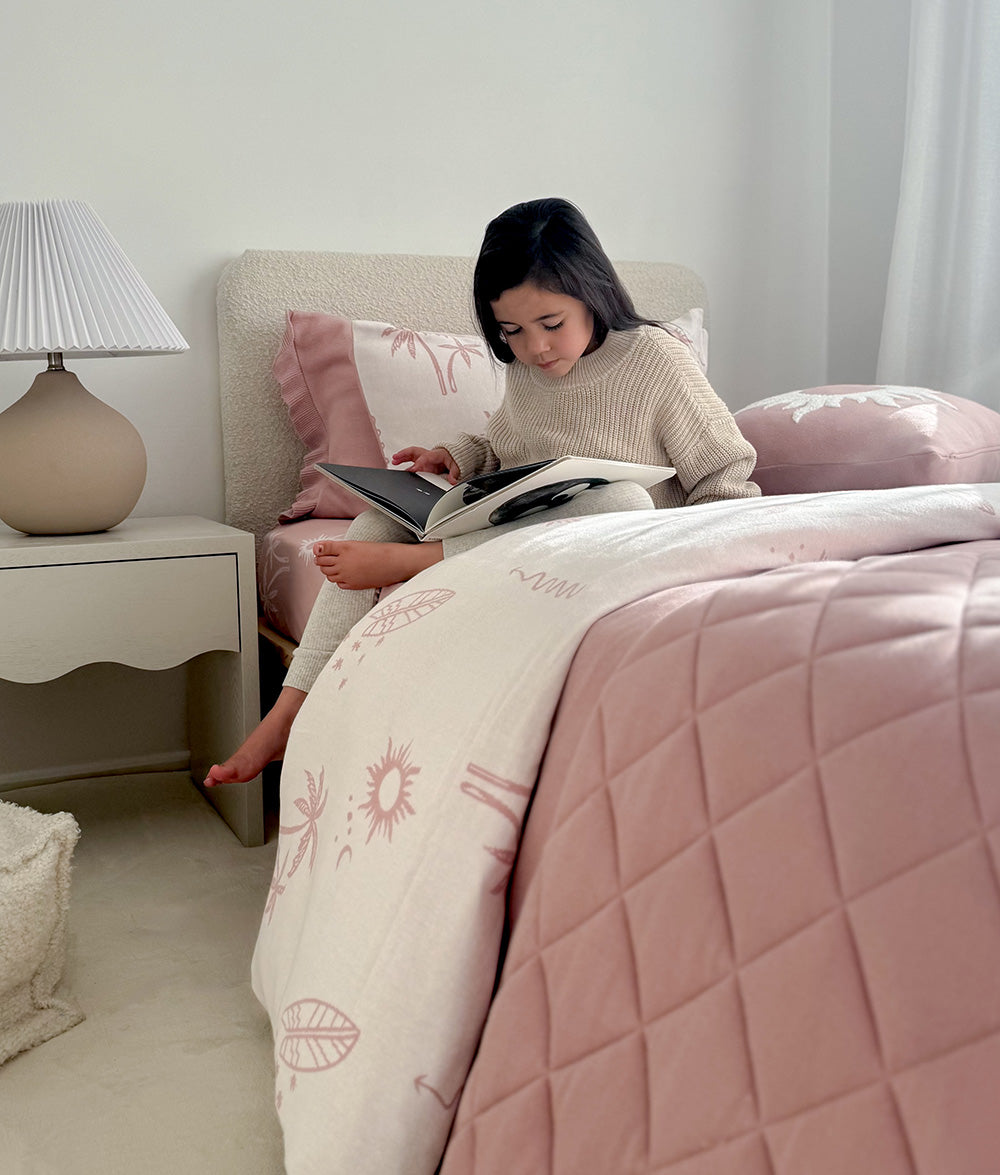 Child reading in the Sun Kissed jersey cotton duvet cover.