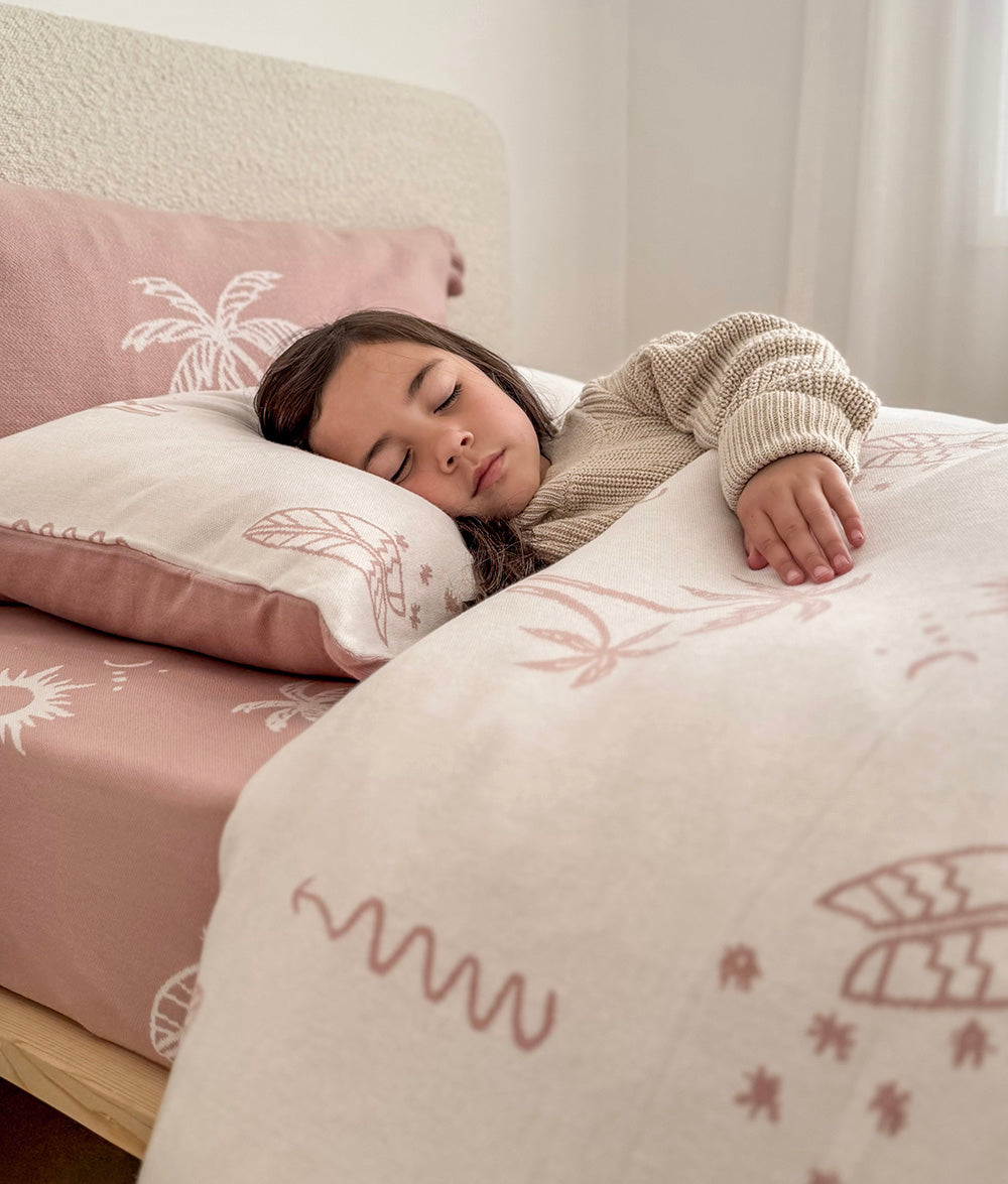 Child resting on the Sun Kissed reversible pillowcase.
