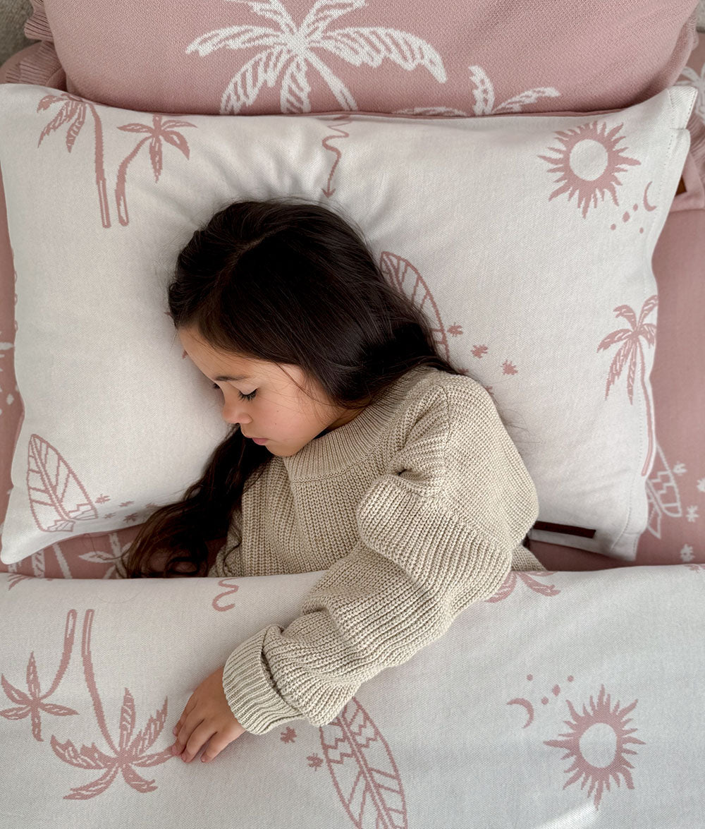 Child resting on the Sun Kissed reversible pillowcase.