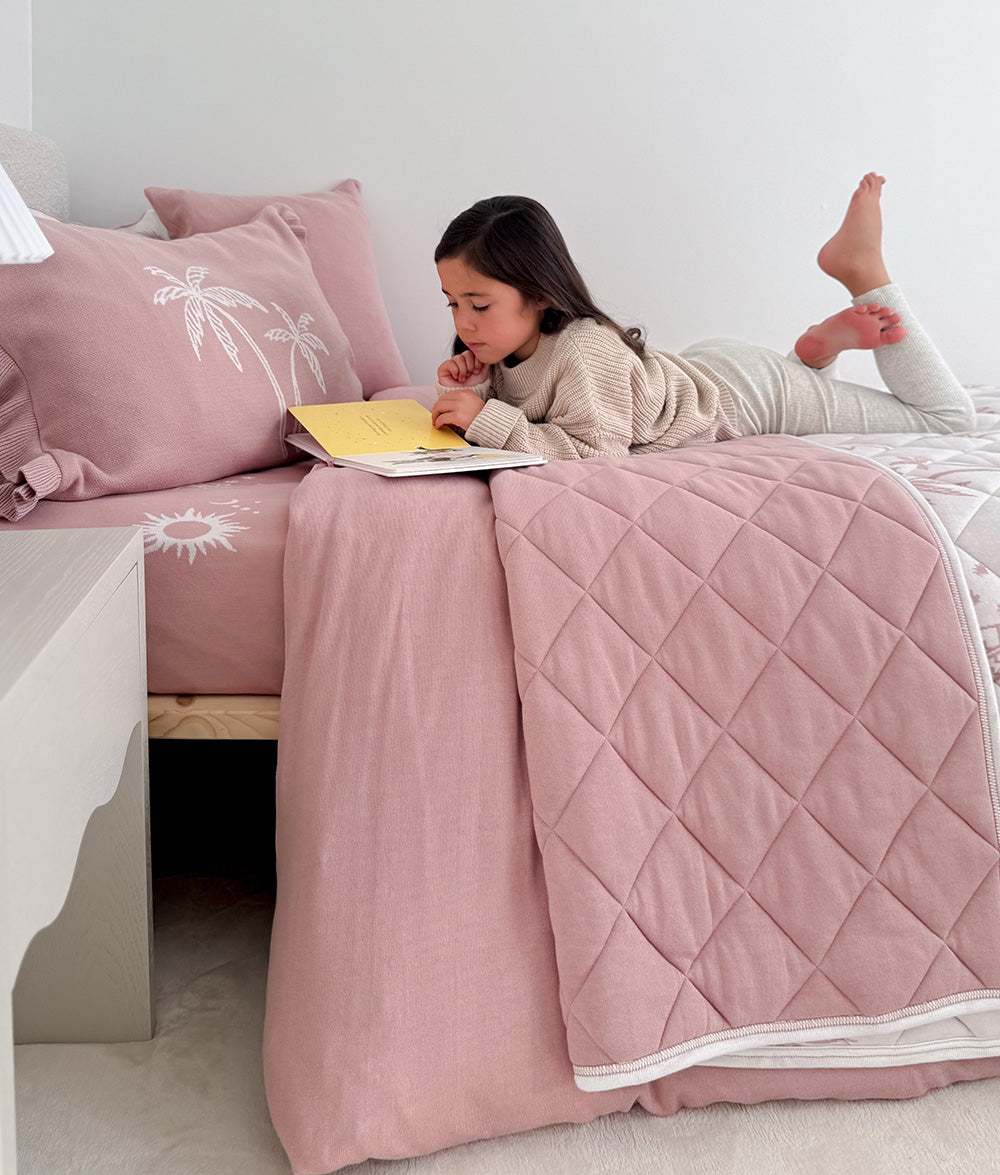 Child reading with the Sun Kissed reversible quilt.