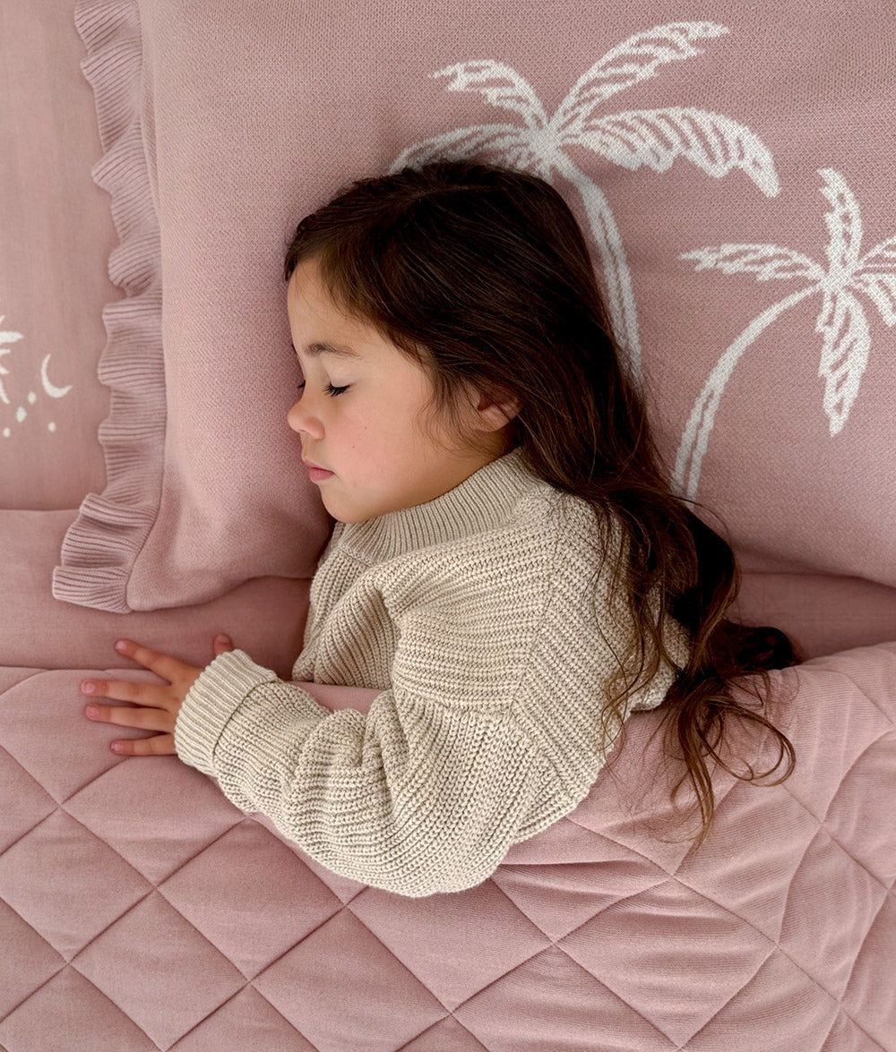 Child sleeping on the "Bare Feet Salty Hair" reversible pillowcase.