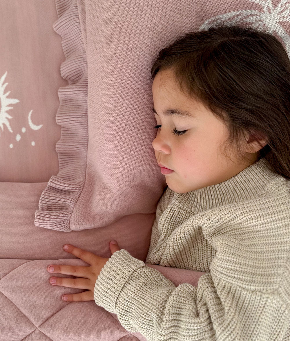 Child resting on the "Bare Feet Salty Hair" reversible pillowcase.