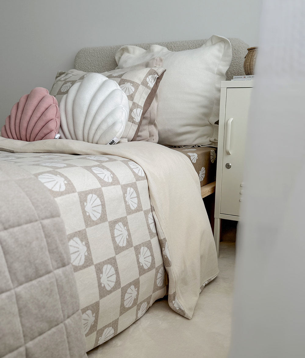 Bed with patterned bedding and decorative pillows in a bedroom setting.