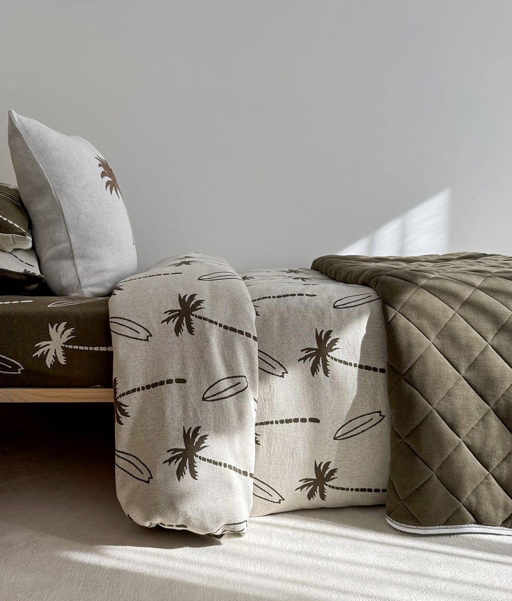 Folded Olive Surfing Palm quilt and matching cushion.