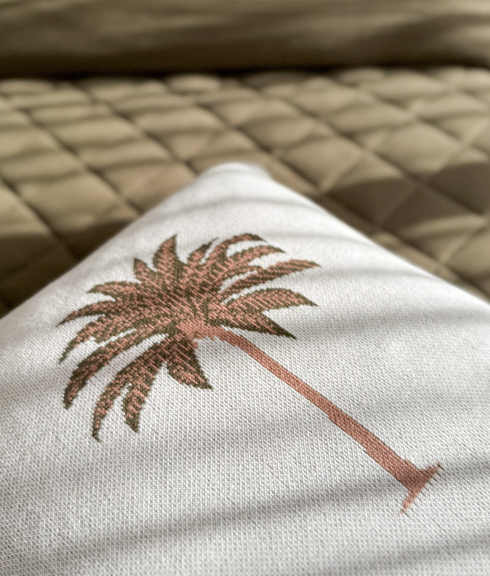 Olive Palm Motif cushion cover on an ivory background.