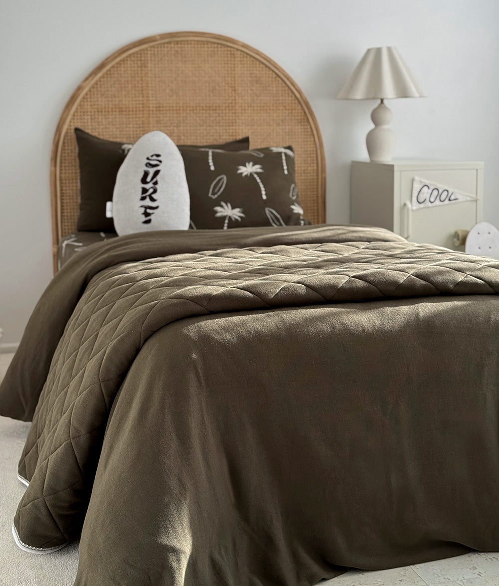 Olive Surfing Palm reversible pillowcase styled on a single bed.