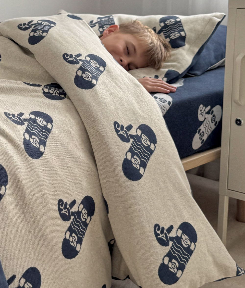 Child wrapped in Tidal Blue Skater Life jersey cotton duvet cover.