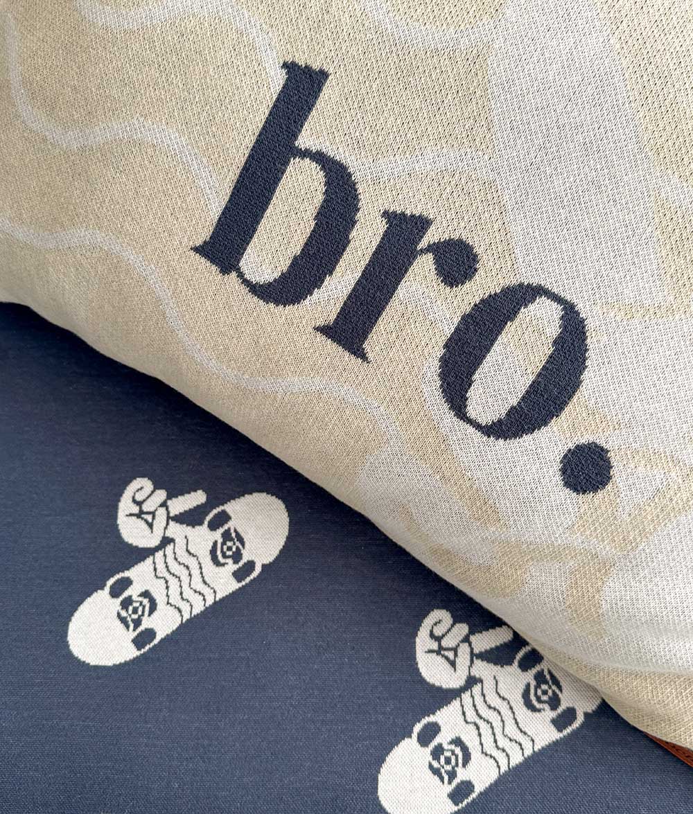 Close-up of the "bro." reversible pillowcase on the tidal blue jersey cotton sheet.